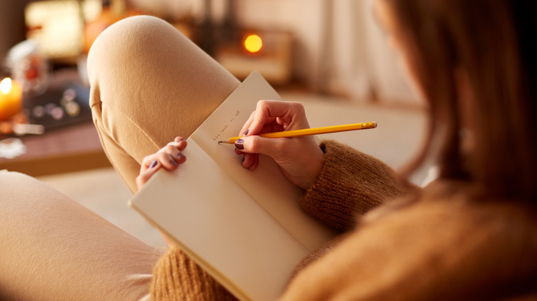 person writing in journal