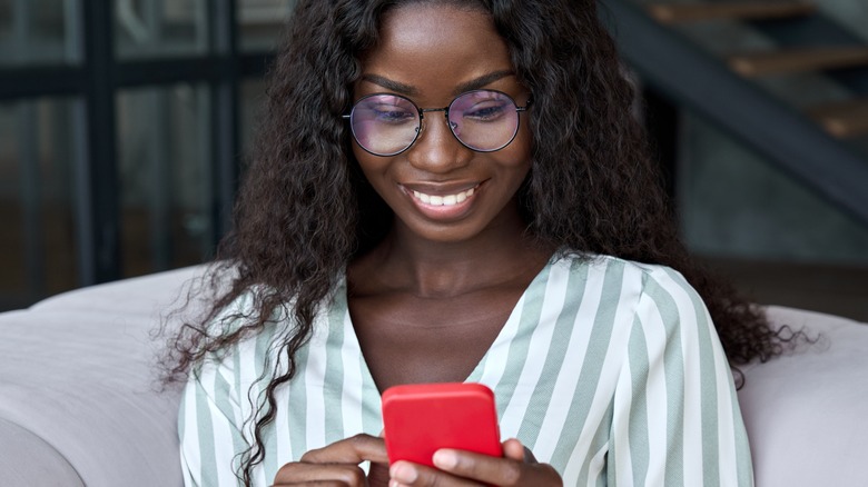 woman smiling while swiping phone 
