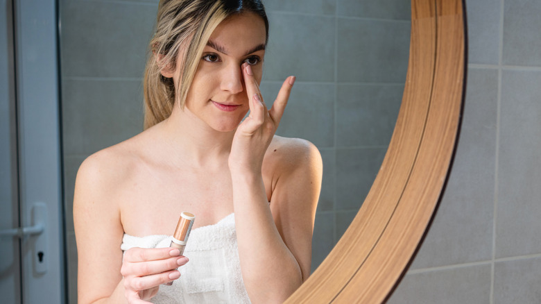 woman applying concealer