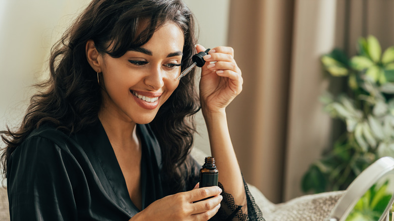 woman applying serum on face