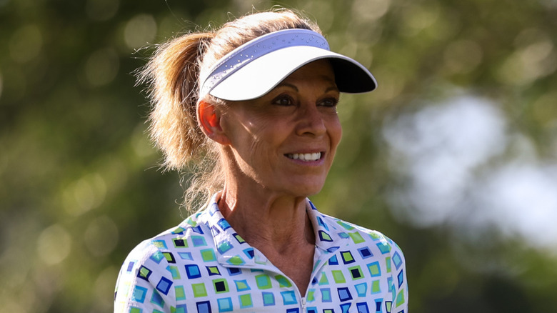 Vanna White wearing a visor and polo while golfing