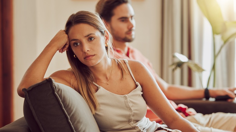 Woman sitting, turning away from man