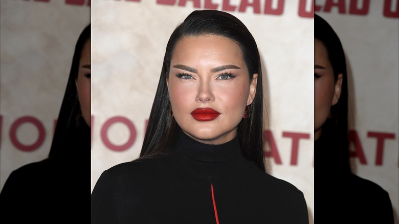 Adriana Lima is seen with dark eyebrows and a bright red lip at a movie screening in 2023
