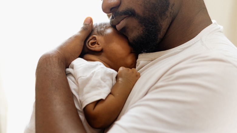 A man holds his infant daughter.