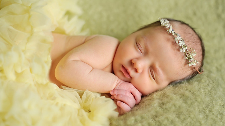 A baby sleeping with a flower headband