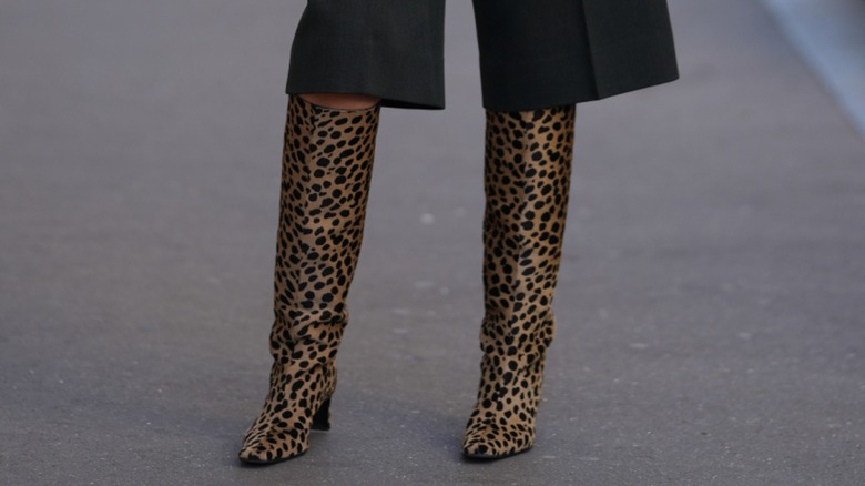 A guest wearing a pair of bermuda shorts and knee-high cheetah print boots during Paris Fashion Week in October 2026