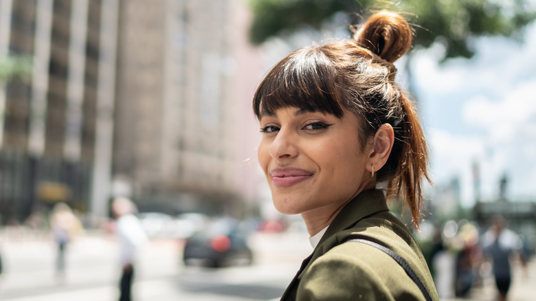 person with bangs smiling