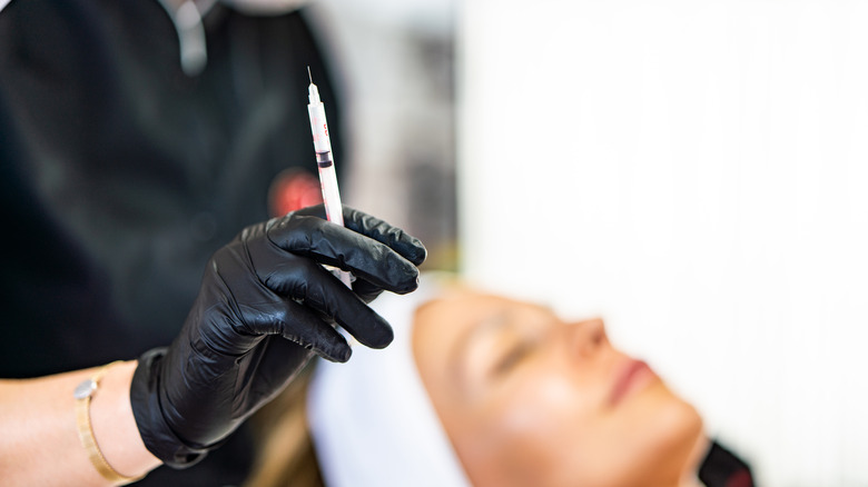 Woman getting ready to give someone a cortisone injection.