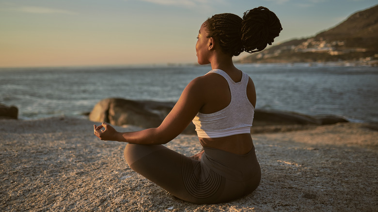 Woman meditating at the beach