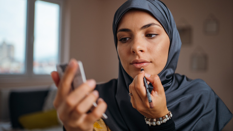 Woman applying lip liner