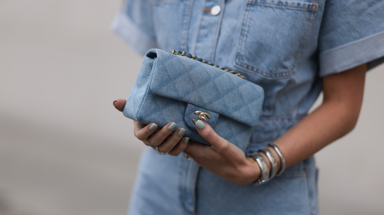 woman holding denim chanel handbag