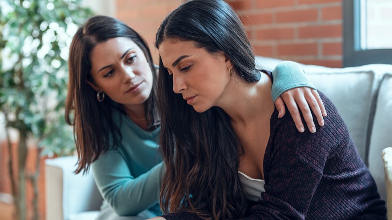 woman comforting another woman