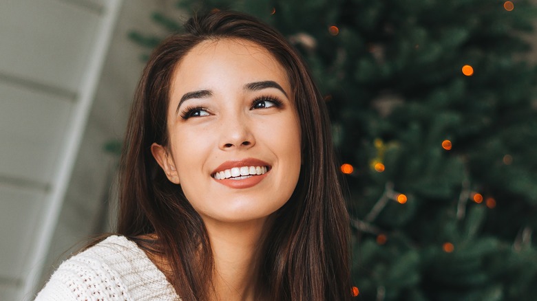 Woman sitting near Christmas tree