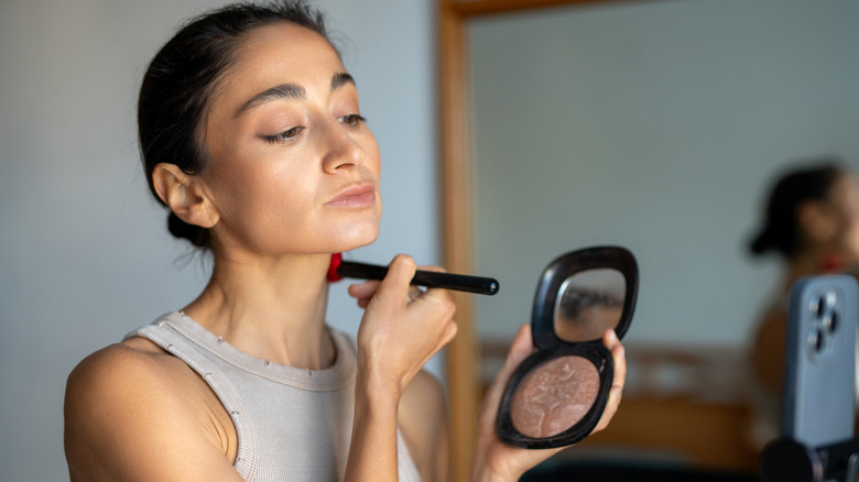 Woman applying bronzer