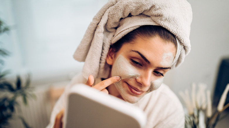 woman applying clay mask