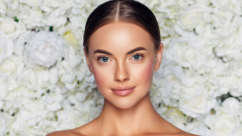 bride in front of flower wall