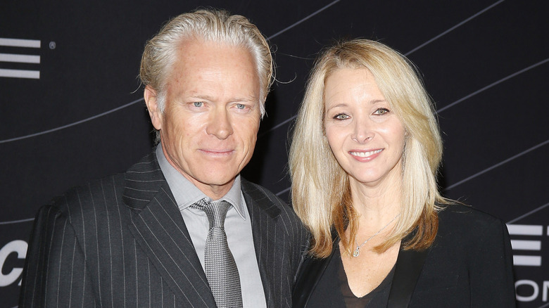Lisa Kudrow wearing a black blazer posing with husband Michael Stern