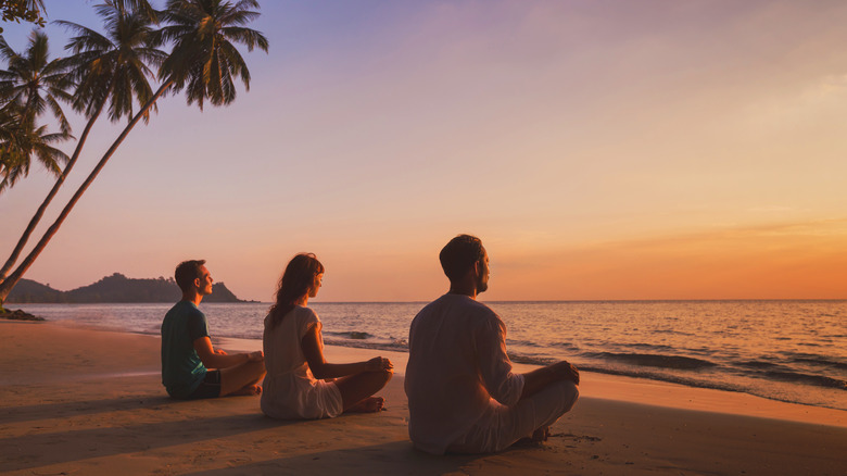 people doing yoga on beach