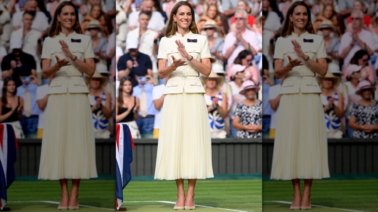 Kate Middleton clapping and wearing a cream-colored pleated skirt and button-up belted top at Wimbledon in 2025.