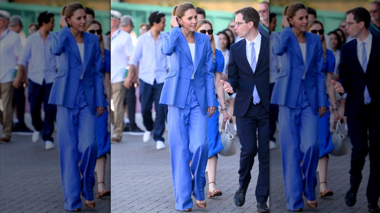 Kate Middleton wearing a loose, cornflower-blue suit with a white T-shirt at Wimbledon in 2026.