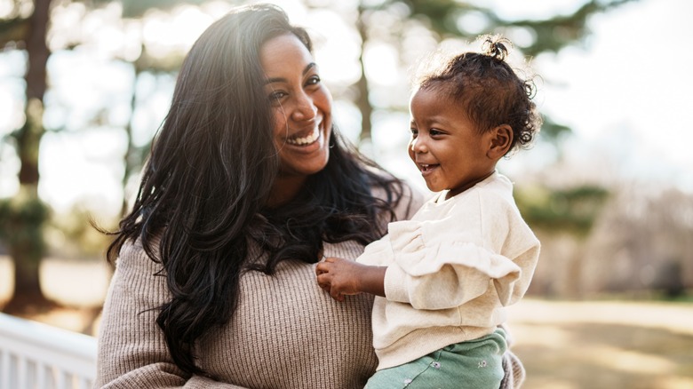 A woman holds her baby daughter.