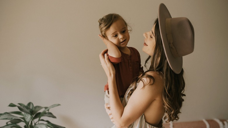 A woman in a Western-style hat holds her toddler.