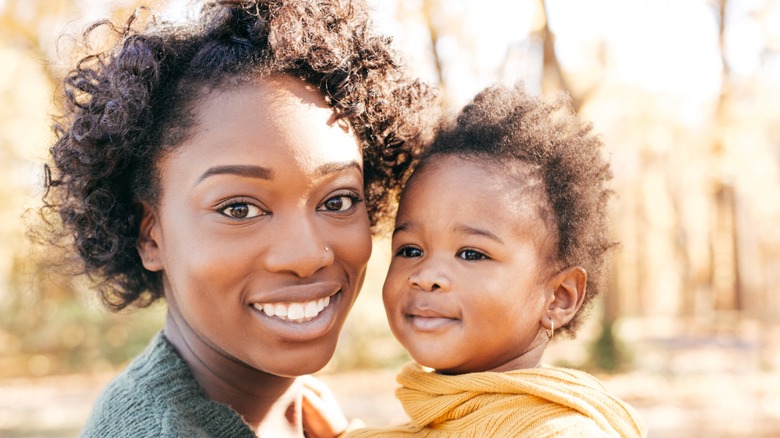 A woman poses with her baby.