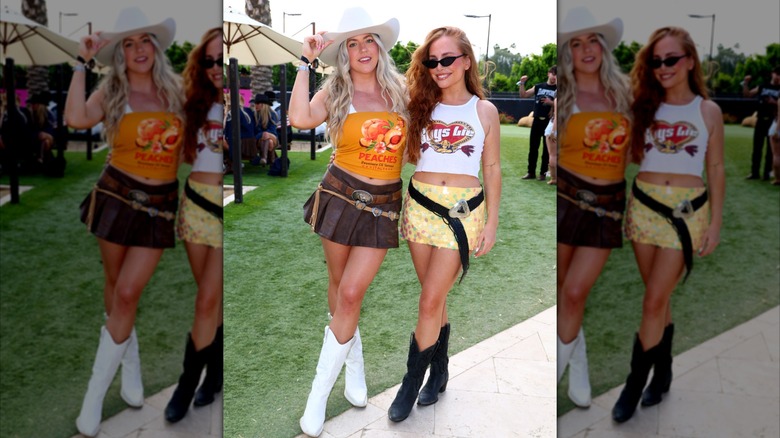 Two women wearing mini skirts, cowboy boots, and Western-inspired belts with large buckles.