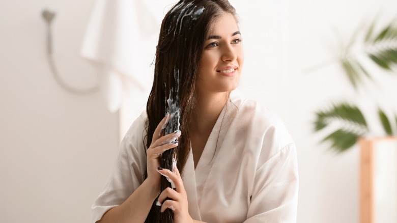 Woman applying mousse to her hair