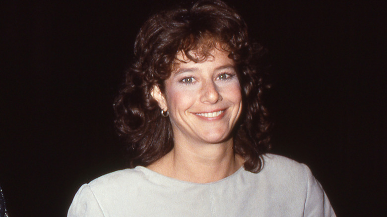 Debra Winger smiles at a photographer in 1984