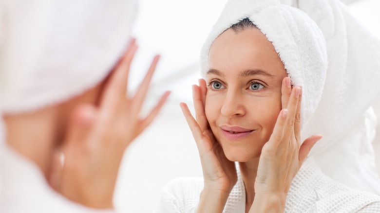 Woman looking at face in mirror