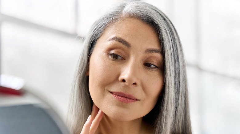 mature woman looking at complexion 