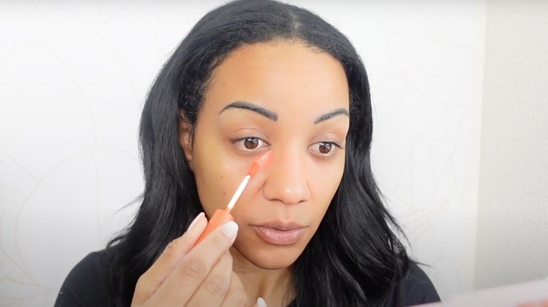 woman applying under eye concealer