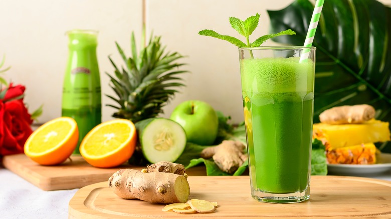 a glass of celery juice surrounded by fruits and vegetables