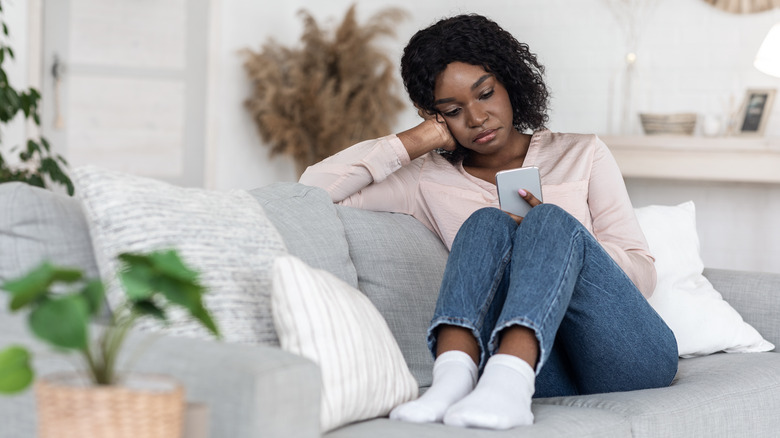 Sad woman looking at phone