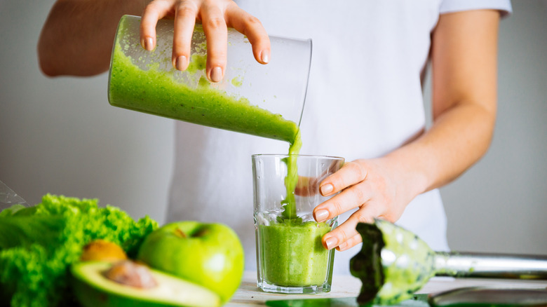 woman preparing a green smoothie