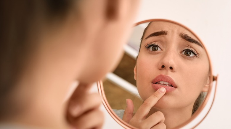 Worried woman looking in mirror