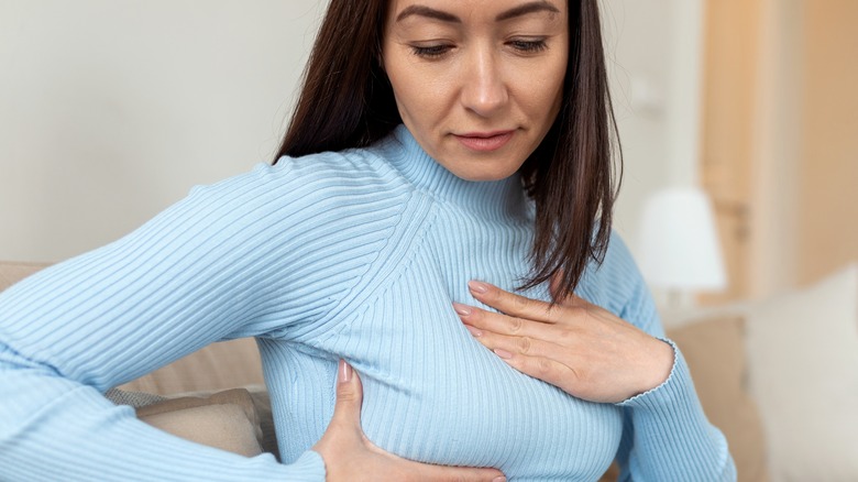 female examining breast lump