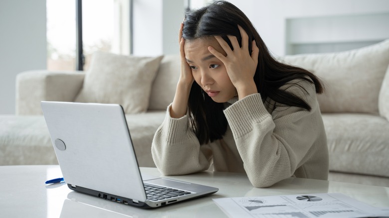 Stressed woman looking at laptop