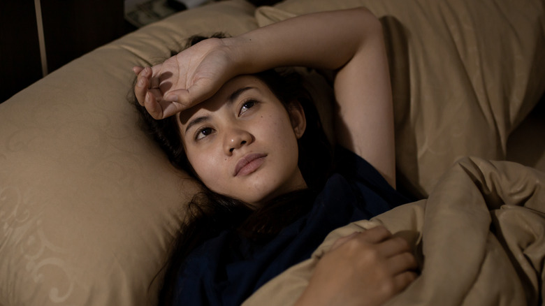 Woman lying in brown bed