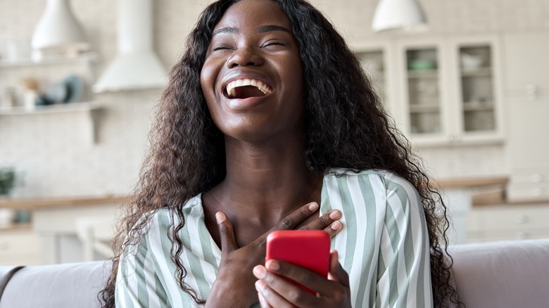 Woman holding phone and smiling