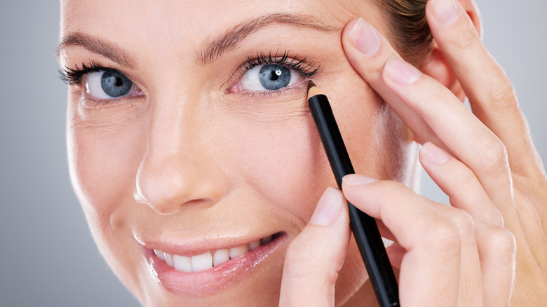 person smiling with pencil eyeliner 