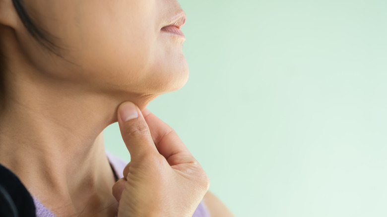 A woman touching her neck