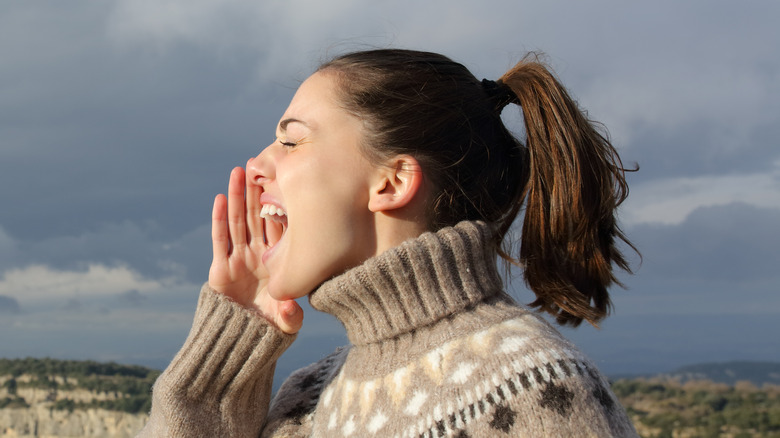 Woman shouting with hands around her mouth