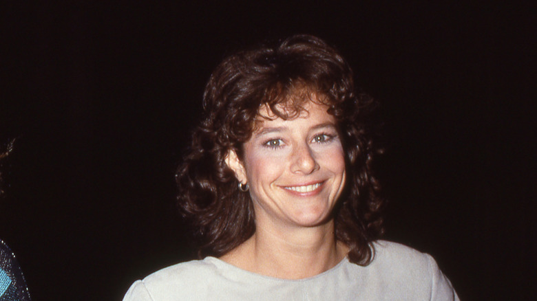 Debra Winger smiles at a photographer in 1984