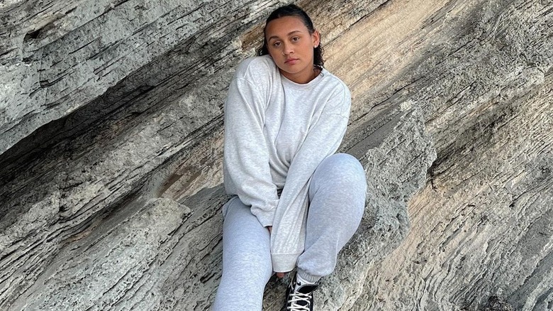 Woman poses in gray sweat suit