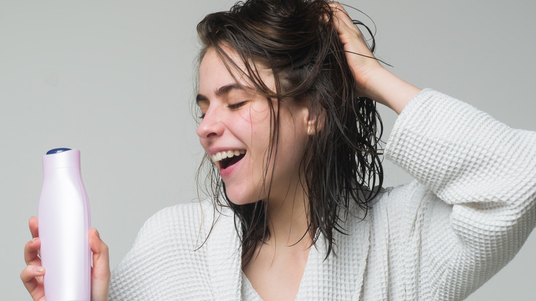 Woman holding a shampoo bottle