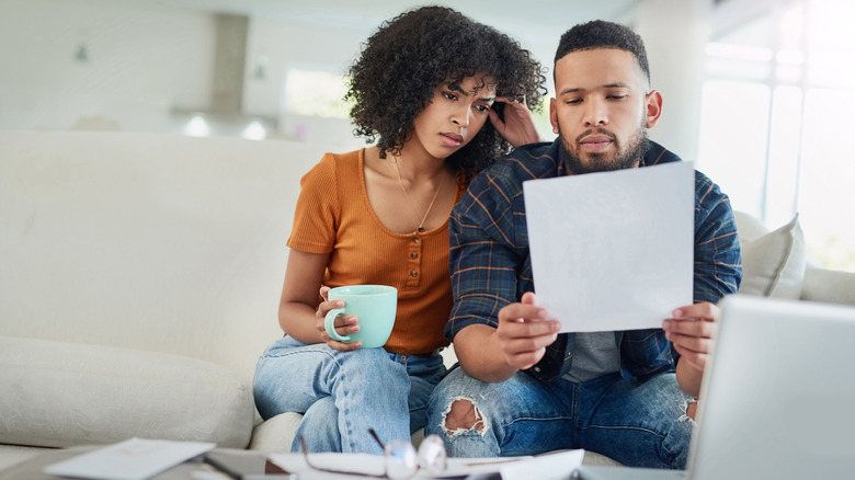 Stressed couple looking at document