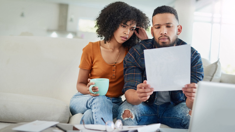 Stressed couple looking at document