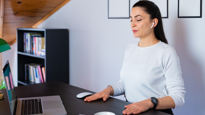 Woman sitting, taking deep breath